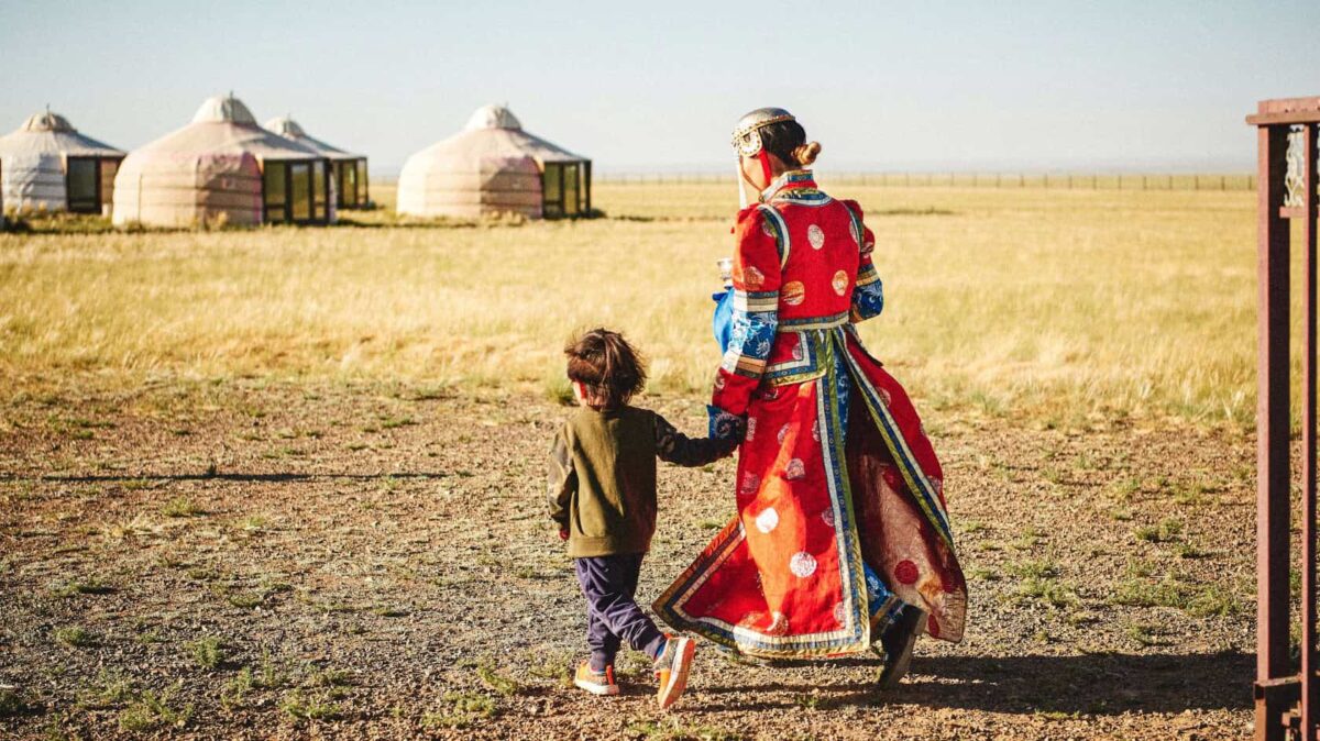 MNG04_Mongolei_GerZuGer_imGerCamp_cKoenigshoferMichael_WEB Mongolei, traditionell gekleidete Frau mit Kind am Weg zu einer Jurte