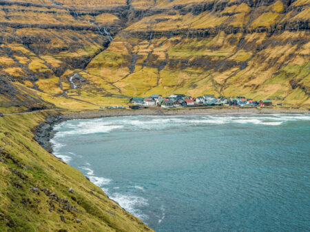 Man sieht eine Ortschaft an der Küste der Färöer-Inseln.