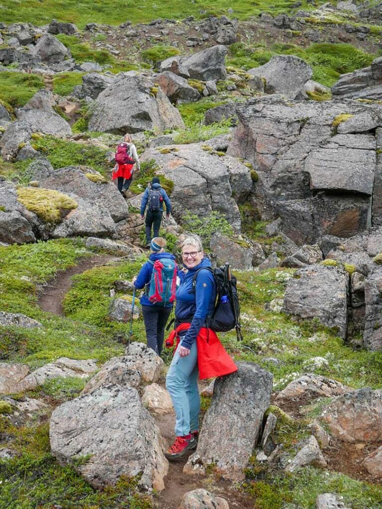 Ein Wanderreisende lächelt inmitten der Felszacken von Hraundrangar in die Kamera