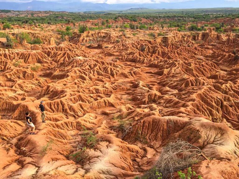 zwei Wanderer stehen vor den roten Felsen der Tatacoa-Wüste