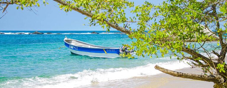 kleines Boot auf türkisblauem Meer in Kolumbien