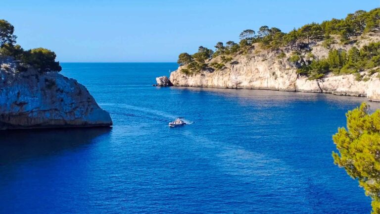 Das Bild zeigt die Calanque de Port-Miou, eine Bucht in der Provence gekennzeichnet durch ihre Kalksteinwände und das tiefblaue Wasser.