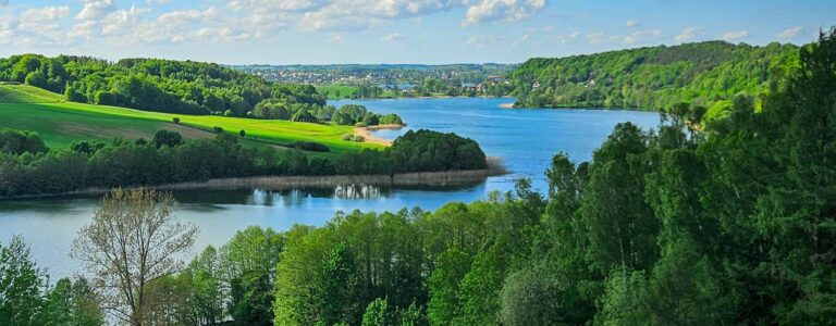 Ein Blick über die malerische kaschubische Seenplatte in Polen mit dichten Laubwäldern und klarem Wasser.